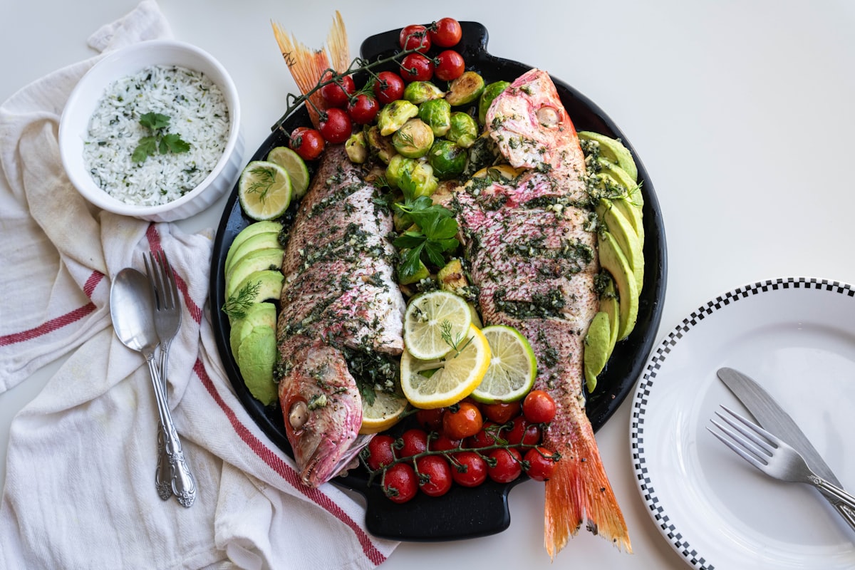 Platou cu pește, legume proaspete și ulei de măsline, simbol al dietei mediteraneene