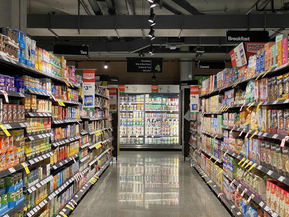Raft de supermarket cu produse ambalate, reflectând strategiile actuale ale industriei alimentare